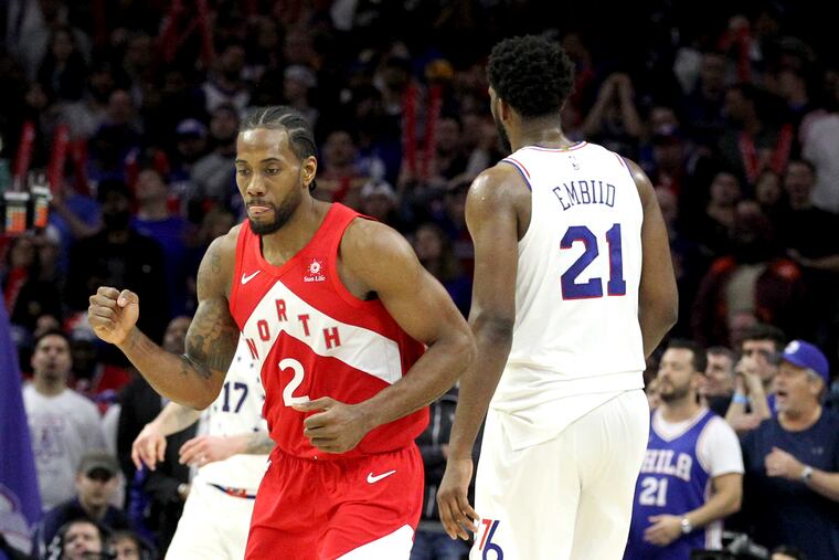 Kawhi Leonard reacts after hitting a three-pointer over Joel Embiid, right, late in Game 4.