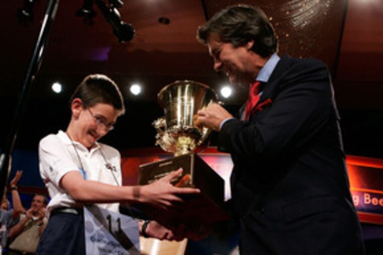 Evan O'Dorney receives a trophy from Kenneth Lowe, president and CEO of E.W. Scripps Co., after winning the 2007 Scripps National Spelling Bee. The contest, which ended last night in Washington, drew a record 286 competitors.