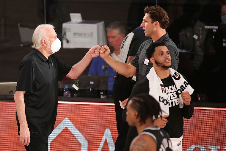 San Antonio Spurs head coach Gregg Popovich, left, and Sacramento Kings head coach Luke Walton greet each other after their game.