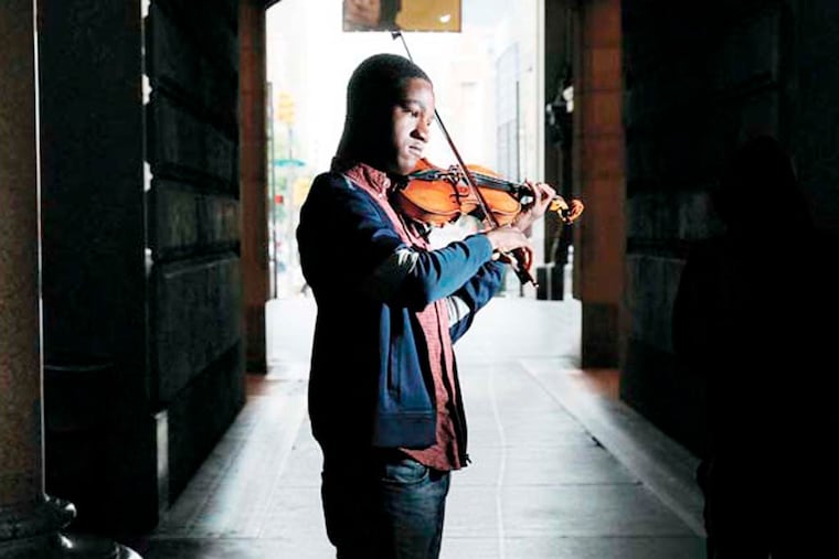 Sean Bennett, 18, plays in the City Hall courtyard for the acoustics as well as to stay out of the weather. The frequent passers-by may also drop some coin in his violin case. Sean Bennett has been playing violin on the streets of Philly since he was 12. Now 18, he's on the Philadelphia Youth Orchestra and still playing the streets. 09/25/2014 ( MICHAEL BRYANT / Staff Photographer )