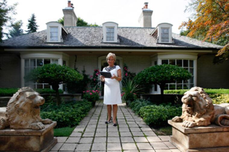 In this Aug. 23, 2011 photo, real estate agent Ronni Keating waits outside for a client to view a home in Bloomfield Hills, Mich. (AP Photo/Paul Sancya)