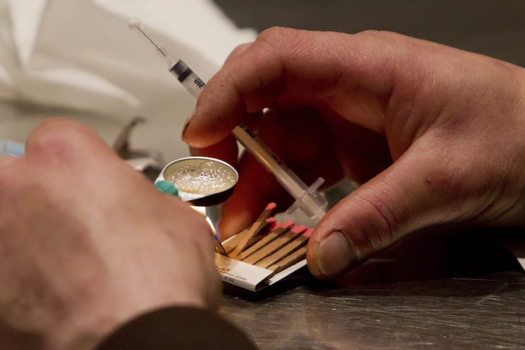 FILE – In this May 11, 2011, file photo, a man prepares heroin he bought on the street to be injected at the Insite safe injection clinic in Vancouver, British Columbia. As part of Philadelphia's effort to combat skyrocketing opioid overdoses, city officials announced Tuesday, Jan. 23, 2018, they want to establish safe havens where people can inject drugs, after members of the city's opioid task force visited Seattle and Vancouver in 2017. (Darryl Dyck/The Canadian Press via AP, File)