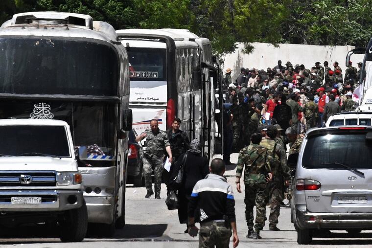 In this file photo from May 15, 2017, militants and their families board buses during evacuation from Qaboun near Damascus to Idlib under a ceasefire agreement.