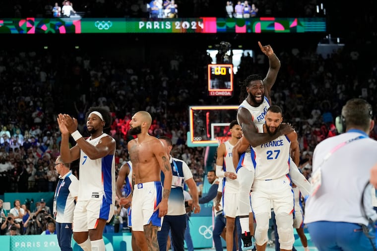 Team France celebrates after beating Germany during an Olympic semifinal at Bercy Arena in Paris.