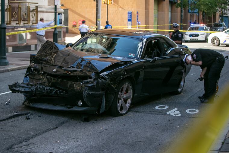 Philadelphia Police investigate damaged Dodge Challenger at 10th and Sansom street in Center City, Philadelphia on Friday, July 12, 2019.