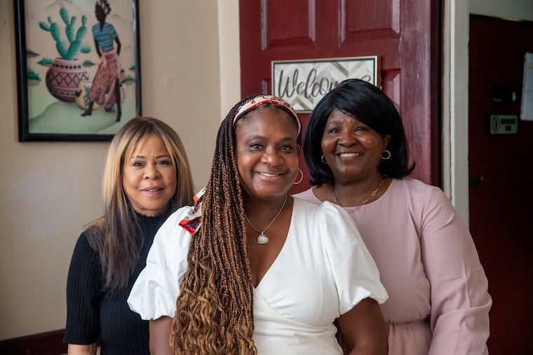 Tracy Taylor-Barkley, center, Kawana Blake, left, and Robyn Burns pose for a photo in August at Taylor's Personal Care Home in Philadelphia. They are part of a small, close knit network of personal care home operators.
