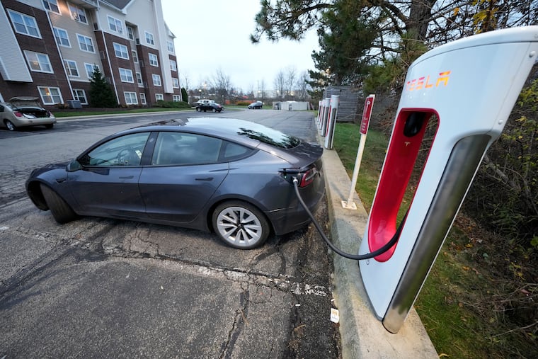 A Tesla sedan gets a charge at a Tesla Supercharging station in Cranberry, Pa. The state legislature has approved an annual fee for owners of electric and plug-in hybrid vehicles.