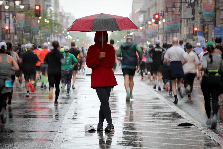 Trina Pilhuj, of Conshohocken, watches for her daughter from the center island on South Broad Street during the 43rd annual Independence Blue Cross Broad Street Run on Sunday.