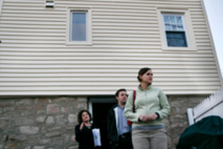 Real estate agent Cheryl Miller, left, shows Tim and Jen Raybould an Abington house that's listed for sale at $249,900.