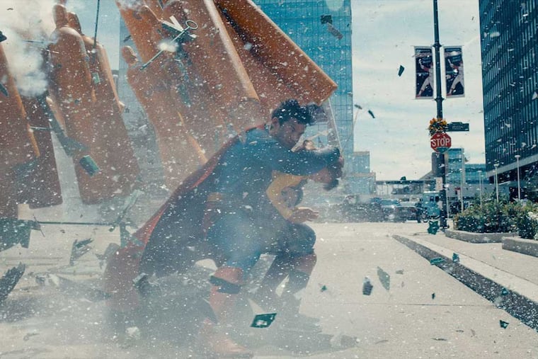 DC / Warner BrothersDavid Corenswet (left) protects a small child from an explosive blast in a scene in James Gunn's new "Superman" movie, premiering on July 11, 2025. Corenswet was born in Philadelphia and is known to be a Philadelphia Eagles fan.