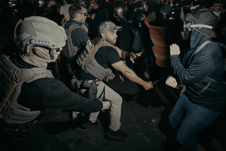 ICE agents use their baton as they clash with protesters outside the Delaney Hall detention center during a protest on Wednesday in Newark, N.J.