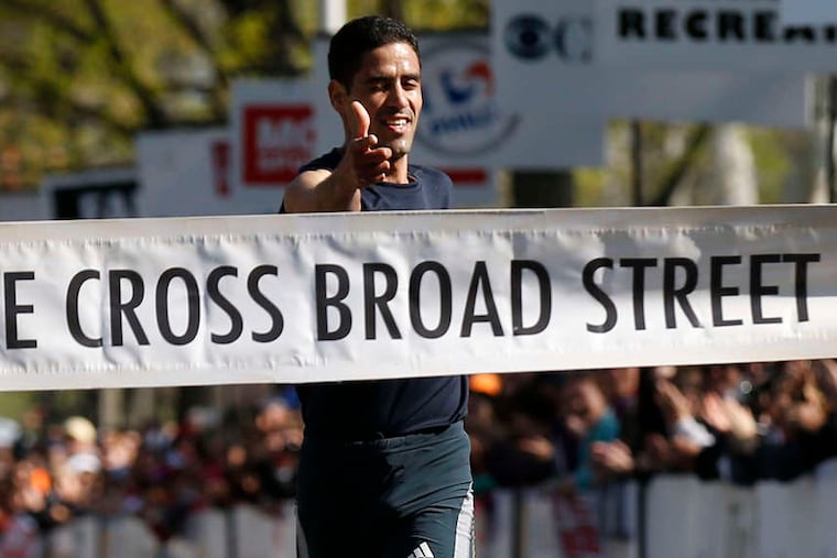 Mourad Marofit reaches the finish line at the Navy Yard after traveling 10 miles down Broad Street in 47 minutes, 7 seconds. YONG KIM / Staff Photographer