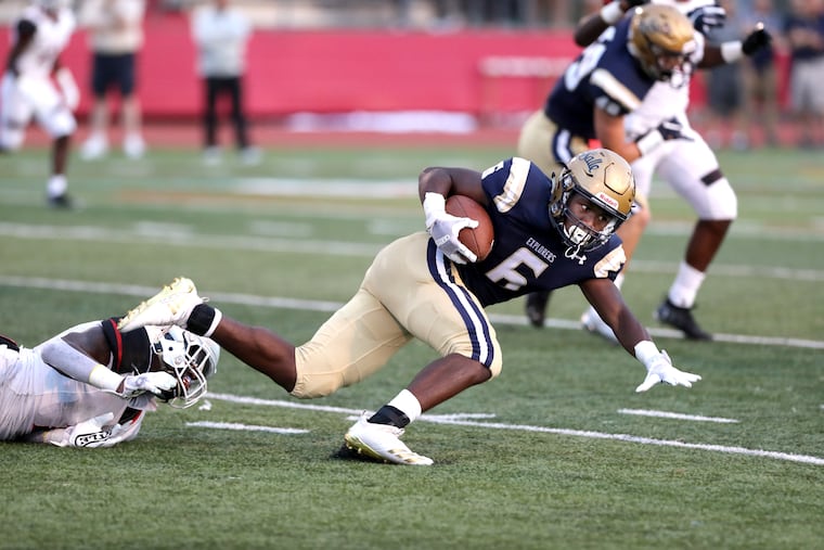 La Salle's Jalen DeVose runs for a gain before being tripped up by Tykee Smith of Imhotep Charter in the 1st half at Upper Dublin High School on Aug. 24, 2018.