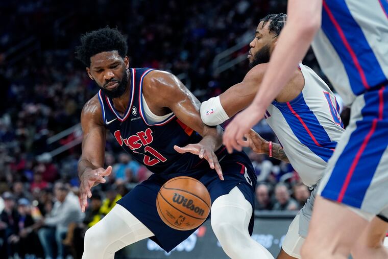 Philadelphia 76ers center Joel Embiid (21) is defended by Detroit Pistons forward Saddiq Bey during the first half of an NBA basketball game, Thursday, March 31, 2022, in Detroit.