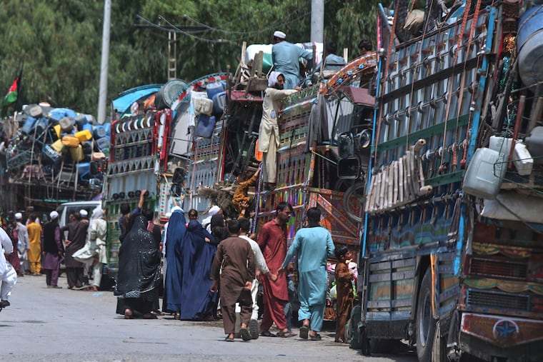 Afghan refugee families heading back to their homeland gather next to trucks loaded with their belongings as they wait for documentation at the UNHCR Voluntary Repatriation Centre in Azakhel, Nowshera a district of Pakistan's Khyber Pakhtunkhwa, Monday, Aug. 25, 2025.