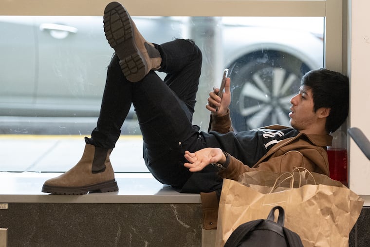 Mark Sharifov informs his relatives on his flight delay at the Philadelphia International Airport in in Philadelphia, Pa. Thursday, Dec. 22, 2022.