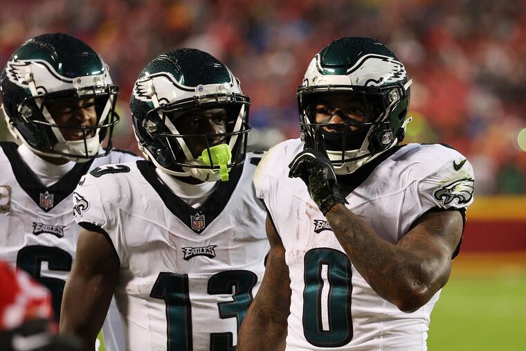 Eagles running back D'Andre Swift (right) tells the crowd in Kansas City to quiet down after his first-quarter touchdown as wide receivers Olamide Zaccheaus (center) and DeVonta Smith join the celebration.