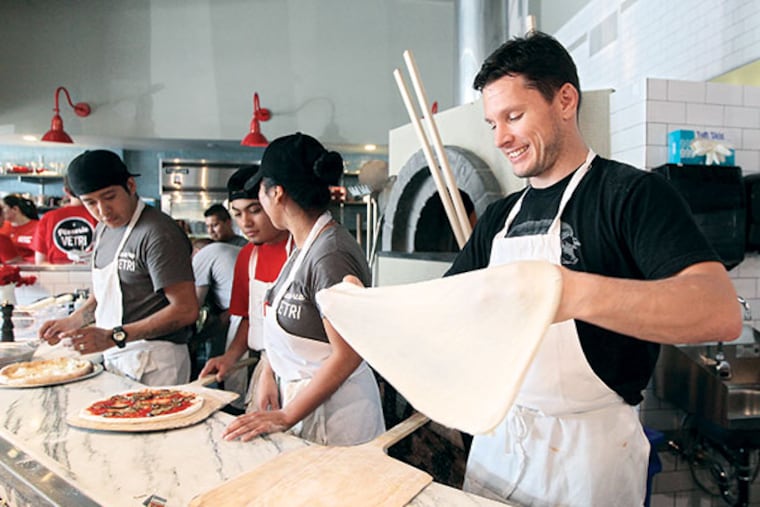 Chef Jeff Michaud, right, works the pizza dough as he prepares to make a margherita pizza at Pizzeria Vetri. ( MICHAEL BRYANT / Staff Photographer )