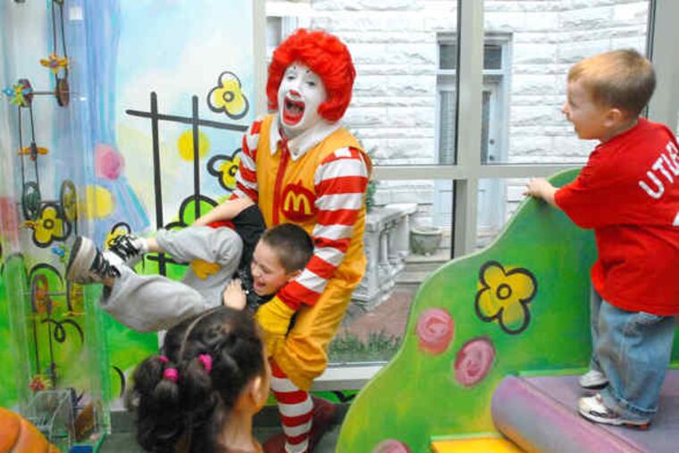 Joey Slawter, 6, of Warrington, clowns around with Ronald McDonald at the West Philadelphia house while Joey's 3-year-old brother, Andrew, laughs at the scene.