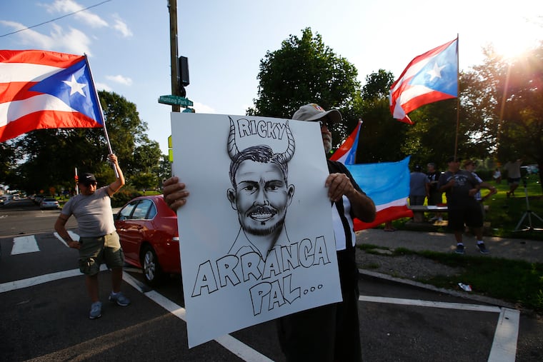 Ángel Medina holds a caricature of Puerto Rico Governor Ricardo Rosselló during a protest against the governor at Hunting Park on Friday, July 19, 2019. The local Puerto Rican community gathered to protest against Puerto Rico Governor Ricardo Rosselló, after the leak of the 889 pages of group chat conversations that throw him into major crisis for racist, sexist and homophobic comments and allegations of corruption in his administration.