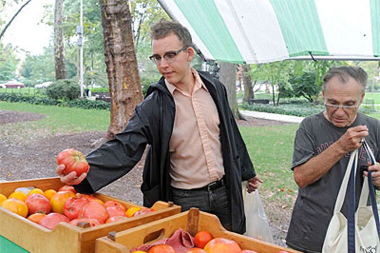Bench Ansfield (left) shops at a farmers market in Clark Park. Farmers markets bring fresh food to the public. (Clem Murray / Staff Photographer)