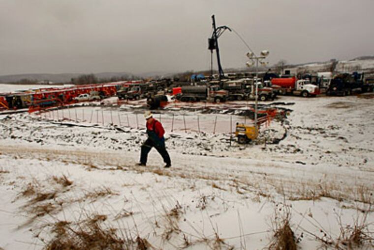 Mark Taylor climbs a hill at East Resource's Fitch gas well in Tioga County. ( Michael S. Wirtz / Staff Photographer )