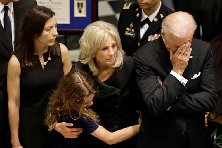 Vice President Biden lowers his head at the Dover viewing for his son as he stands with (from left) Beau Biden's wife, Hallie, and daughter, Natalie, and the vice president's wife, Jill Biden.