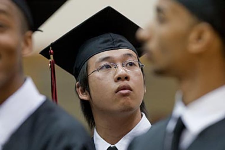 Wei Chen (center) and fellow seniors search the audience for families and friends. “I’ve done my job — almost done,” he said. (DAVID M WARREN / Staff Photographer)