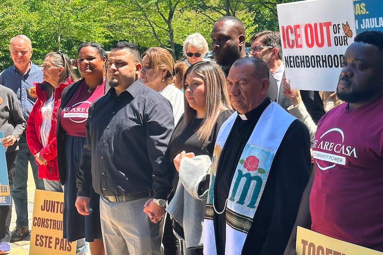 Kilmar Abrego Garcia and his wife, center, hold hands as people rally in support of him at a news conference outside federal court after a hearing in his case on Tuesday, May 12, 2026, in Greenbelt, Md.