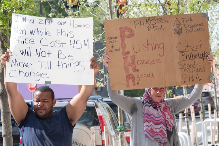 Community members hold signs as they occupy the PHA headquarters in May, in protest for more transparency and accountability.