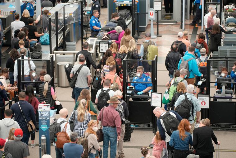 Travelers queue up move through the north security checkpoint in the main terminal of Denver International Airport on Thursday in Denver.