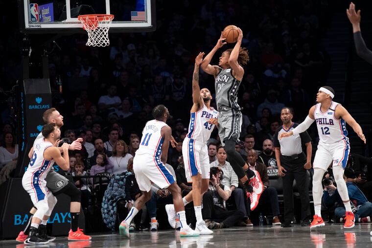 Brooklyn Nets forward Nicolas Claxton goes to the basket past 76ers forwards James Ennis III (11), Jonah Bolden (43) and Tobias Harris (12) during the first half.