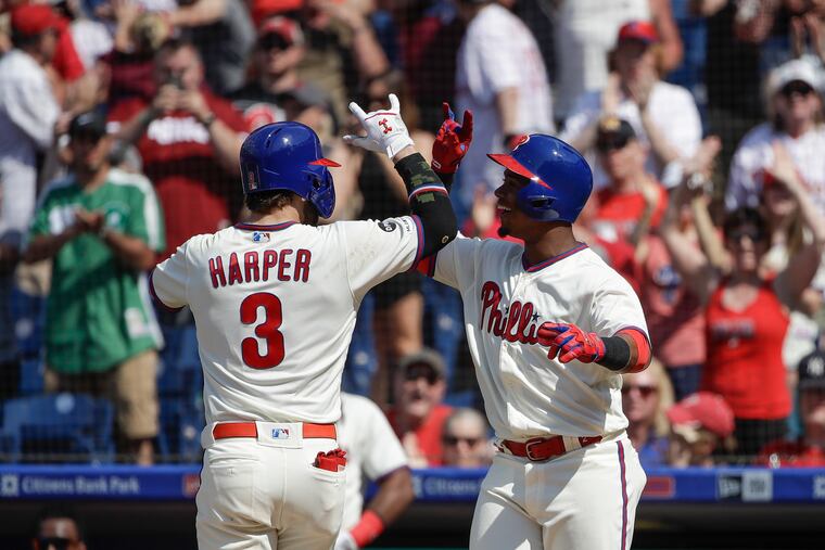 Philadelphia Phillies' Bryce Harper celebrates with Jean Segura after hitting a home run with one run batted in during the sixths inning of a baseball game Sunday, May 19, 2019, in Philadelphia. The Phillies won 7-5. (AP Photo/Matt Rourke)
