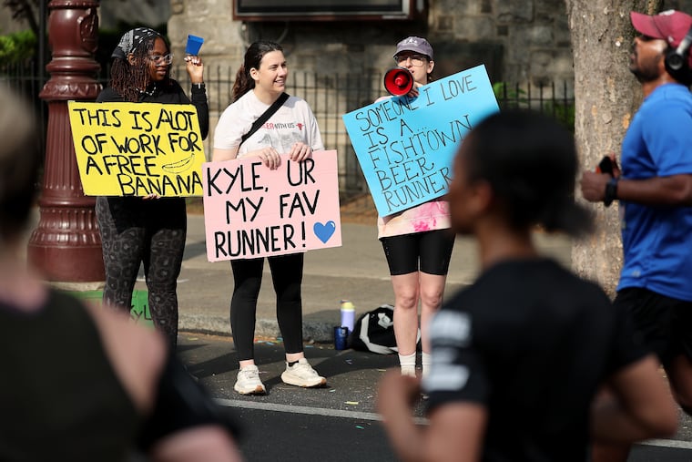 Elizabeth Jackson (left), Rachel Kostelz (center) and Gracie Stagliano (right) cheer on runners in the Independence Blue Cross Broad Street Run.