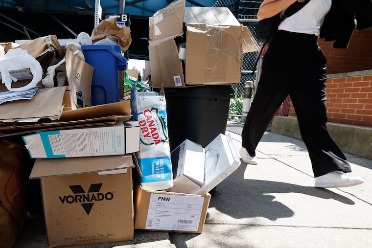 A pedestrian walks near uncollected recycling items along the 200 block of N. Third Street in Old City on Monday.