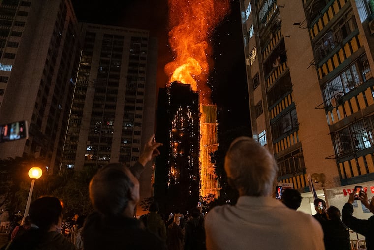 People look at flames engulfing a building after a fire broke out at Wang Fuk Court, a residential estate in the Tai Po district of Hong Kong's New Territories, on Wednesday, Nov. 26.