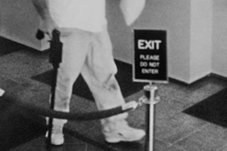 In a 2003 photo provided by the FBI, Brian Wells carries a plastic bag of cash after robbing a PNC bank in Erie.