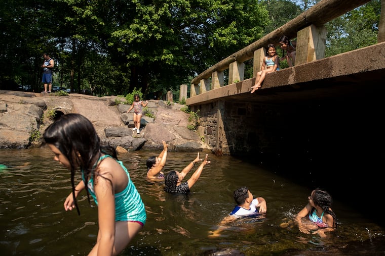 Kids play in Neshaminy Creek at Tyler State Park in Newtown, Pa. on Wednesday, July 7, 2021. The high in Philadelphia on Wednesday was 96 degrees.