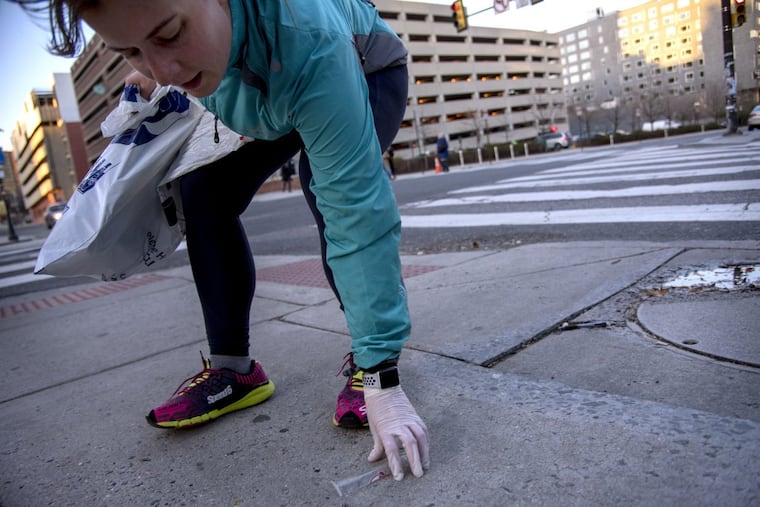 Aleks Cocic stops at 34th & Chestnut Streets to pick up a piece of trash, as she runs with the West Philly Runners, along with the Clean Air Council and Not in Philly trying out plogging.