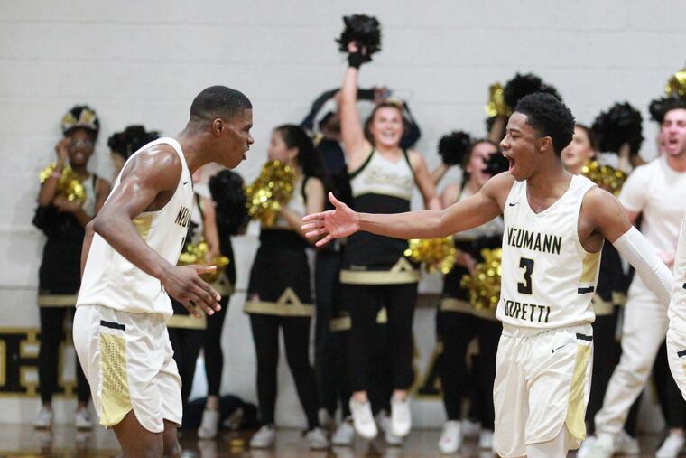 Hysier Miller (left) and Hakim Byrd of Neumann Goretti celebrate in the final moments of their team’s victory over Roman Catholic in double overtime.
