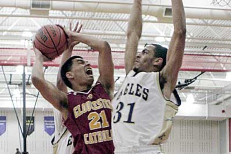 Gloucester Catholic's Kevin Cano, left, looks to shoot over Cardinal McCarrick's Will Thomas. (Elizabeth Robertson/Staff Photographer)
