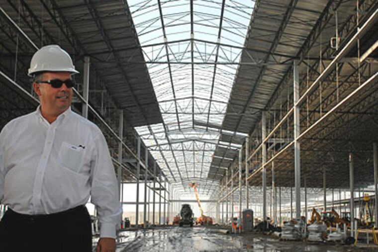 Developer Brian O'Neill on the site as construction continued on the new Philadelphia Regional Produce Market on Essington Avenue in August. The 686,000-square-foot "project will shut down" soon unless state lawmakers approve paying invoices totaling $15 million owed to contractors. (Tom Gralish / Staff Photographer)