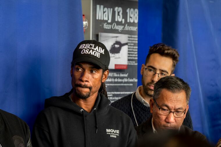 MOVE family member Mike Africa Jr. listens during the speeches before the unveiling of a new permanent MOVE exhibit. He was 6 years old at the time of the bombing. Tu Huynh (right) curated the exhibit.