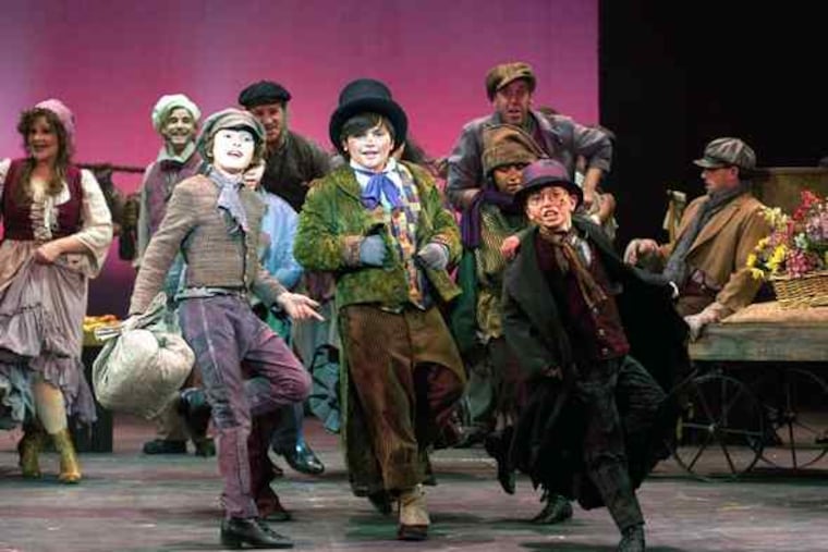 Walnut Street's "Oliver!" stars, amid 71 total actors, Brandon O'Rourke (center) as Artful Dodger and Gregory Smith (with bundle) as Oliver.