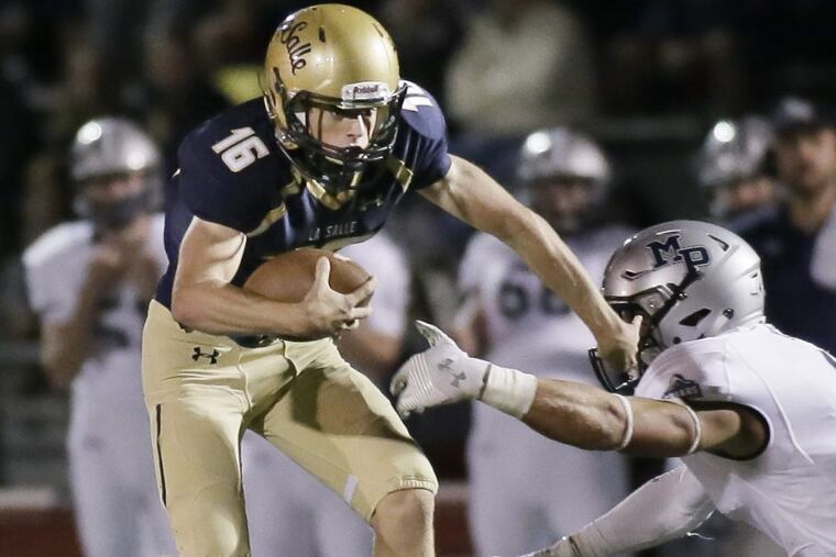 LaSalle quarterback (left) Danny Solecki tries to avoid Malvern Prep’s Keith Maguire on Sept. 9.