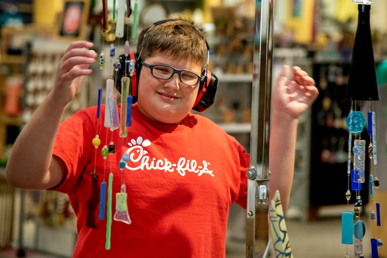 Emmett Tolis stops to look at wind chimes for sale at the Mercantile in Doylestown Sept. 27, 2022, where his paintings are also on display. He has a diagnosis of Autism Spectrum Disorder and his family has found it difficult to find him residential treatment. The Mercantile is a space for local artists and art lovers and small businesses to “meet, connect, and engage.”