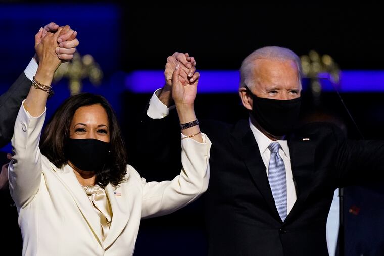 In this Nov. 7 photo, Vice President-elect Kamala Harris (left) holds hands with President-elect Joe Biden.