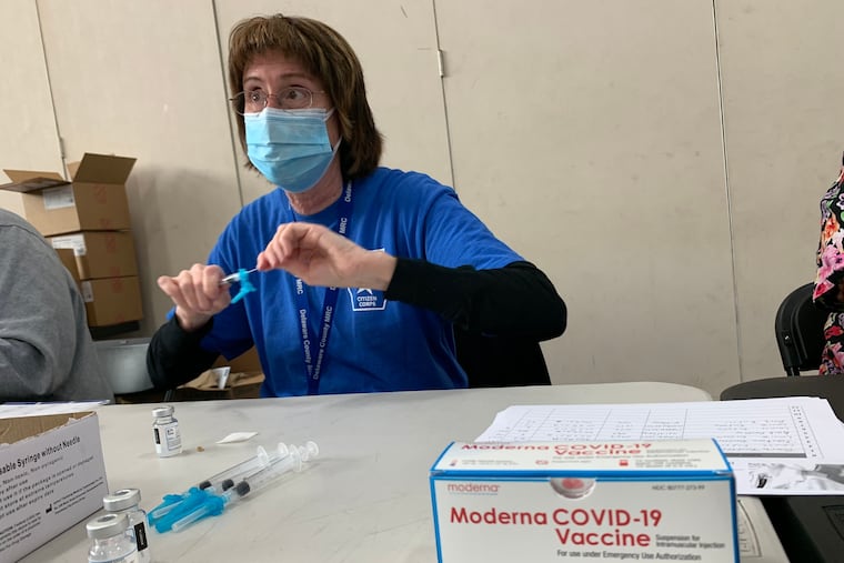 Nurse Louise Enderle draws Moderna COVID-19 vaccine into a syringe at a pop-up mass vaccination site at Upper Darby High School on March 14, 2021.