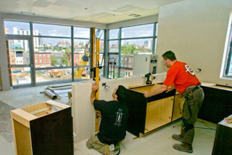Workers install kitchen cabinets in Carl Dranoff's new apartment complex, named 777 and located at 777 South Broad St. ( Clem Murray /Staff Photographer )