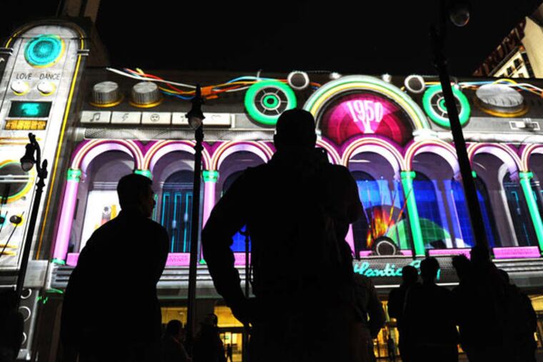 Spectators enjoy the kinetic “Boardwalk Beat” show projected on Atlantic City's Boardwalk Hall. A $253 million bond offering planned for this week by the New Jersey Casino Reinvestment Development Authority includes $60 million that will be paid for a settlement linked a renovation of Boardwalk Hall that started in 1998.